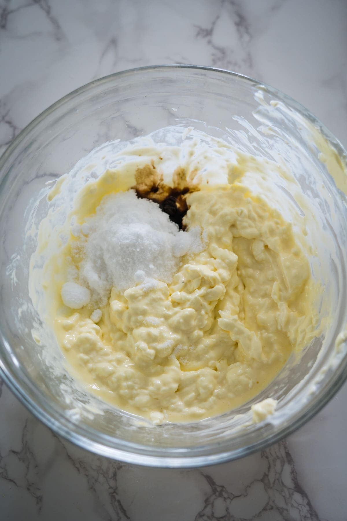 A glass bowl filled with creamy butter and sweet sugar.