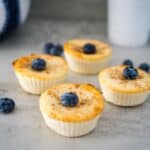 Four cream cheese muffins with blueberries on a table.