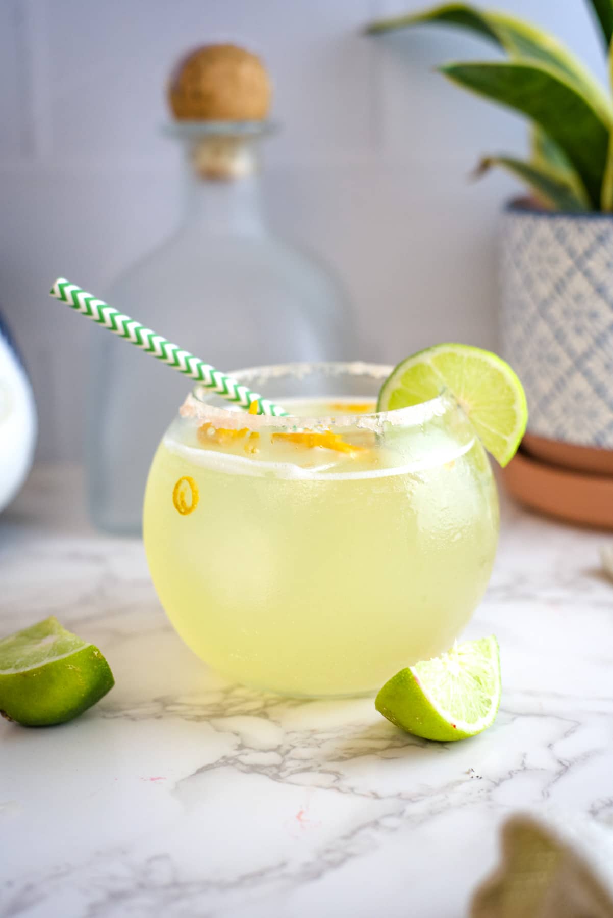 circular glass with a straw, filled with a margarita