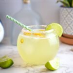 bowl shaped glass filled with a lime margarita drink