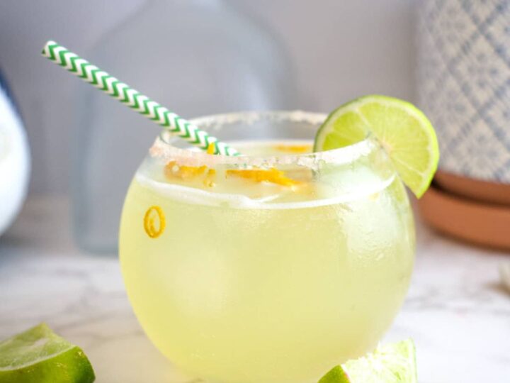 bowl shaped glass filled with a lime margarita drink