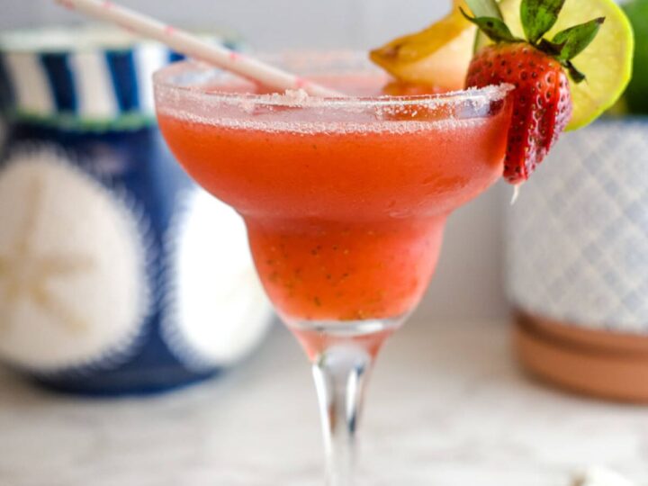 a glass of strawberry daiquiri with fruit garnish