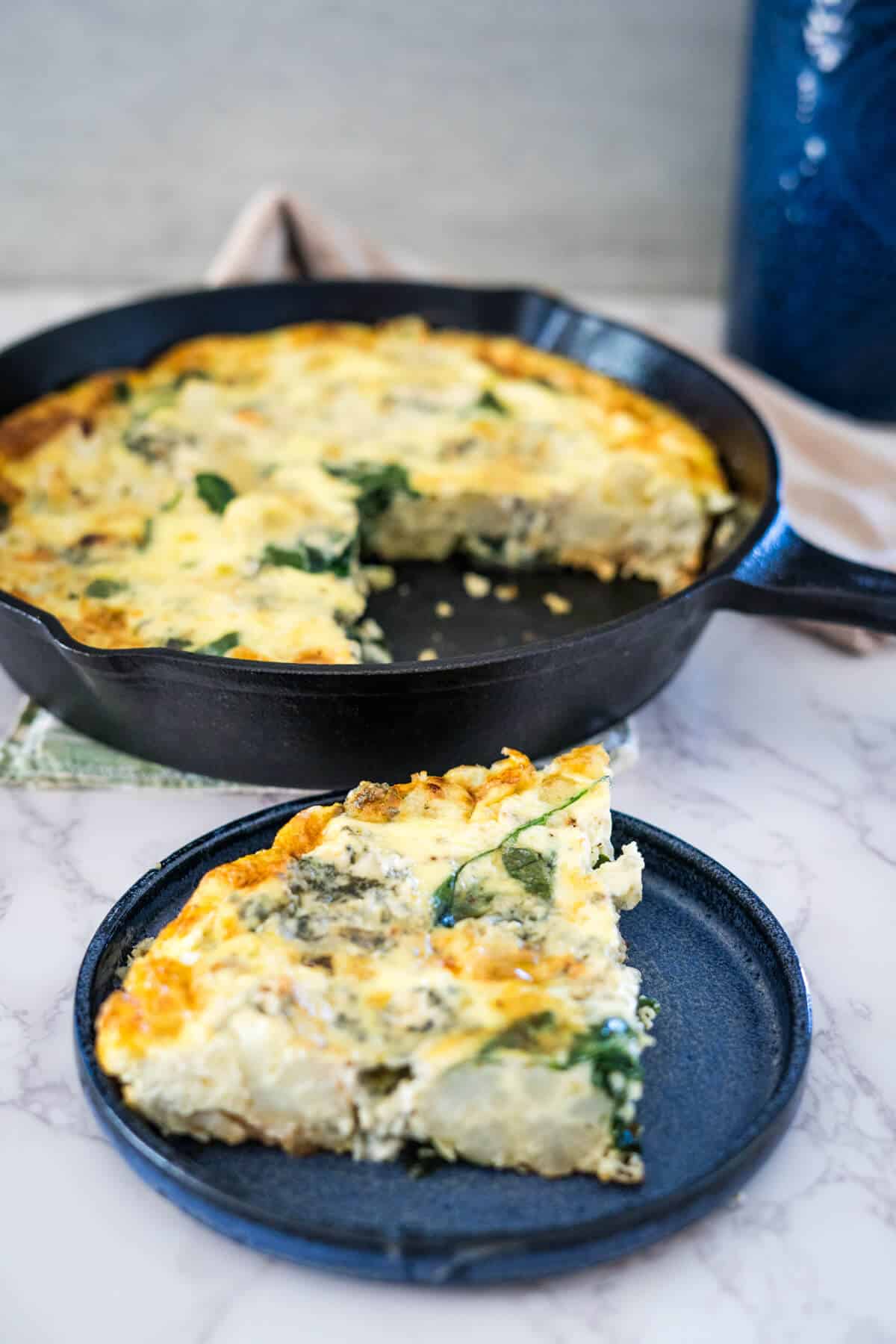 A frittata with spinach and cheese on a plate.