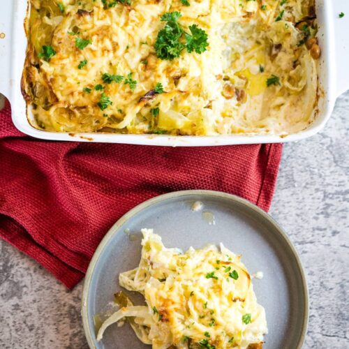 A dish of mashed potatoes with cheese and parsley.