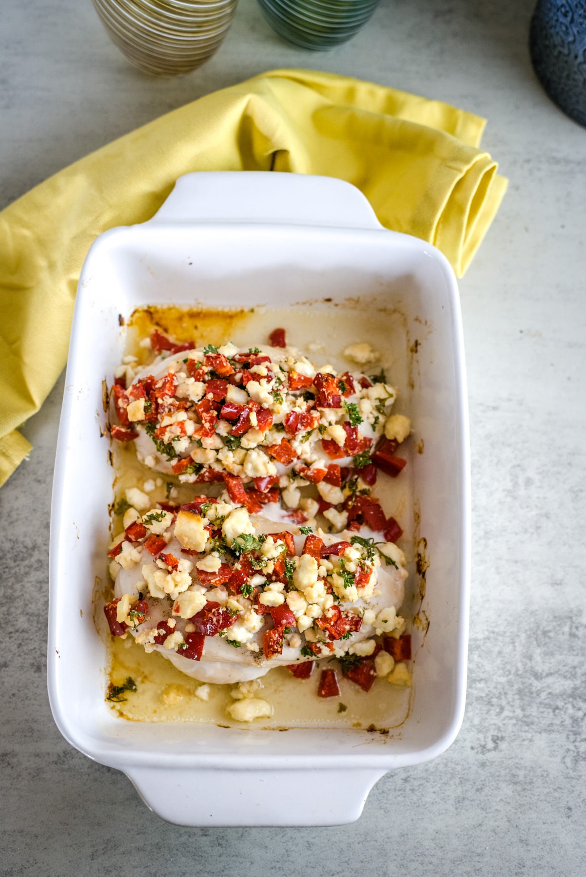 baked chicken with feta and red pepper on top.