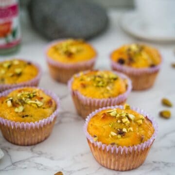 Pistachio muffins with rosewater-infused pistachios on a marble table.