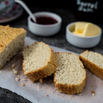 Irish coconut bread with jam and butter on a piece of paper.