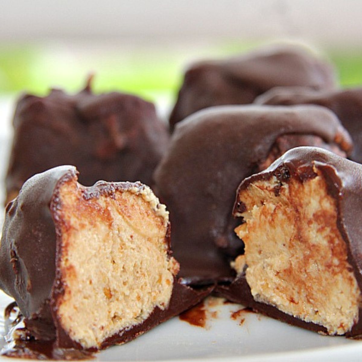 Keto chocolate peanut butter balls on a plate.