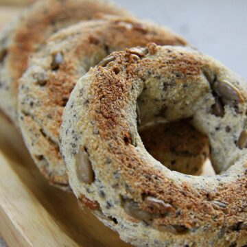 Close-up of sunflower chia seed bagels on a wooden board.