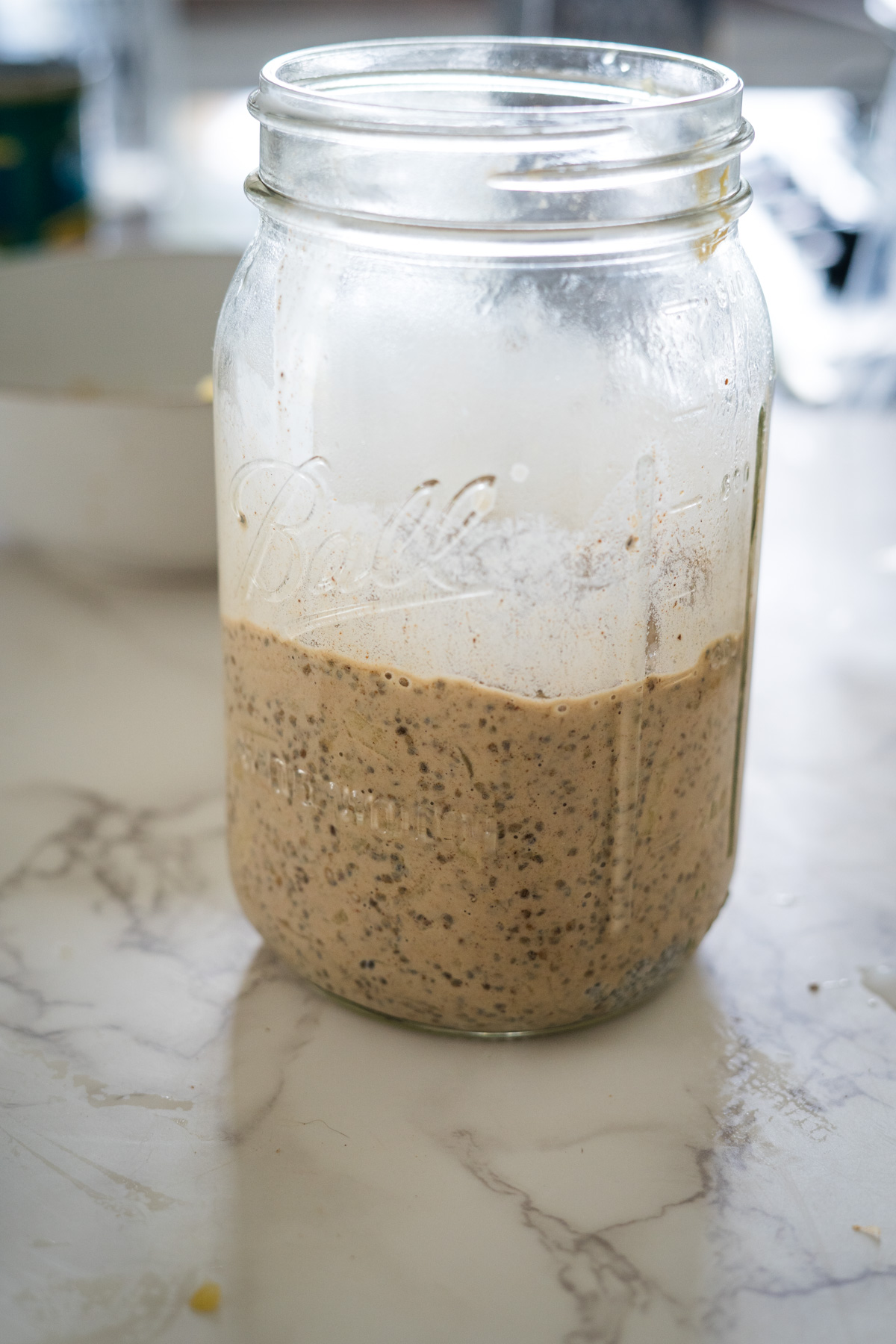 A jar filled with a chia mixture on a counter.