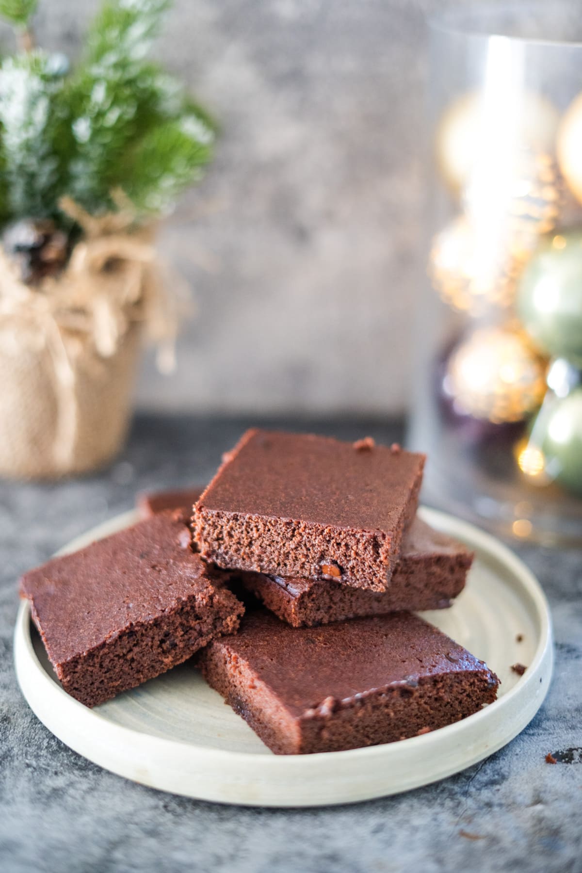 Spiced brownies on a plate in front of Christmas decorations.