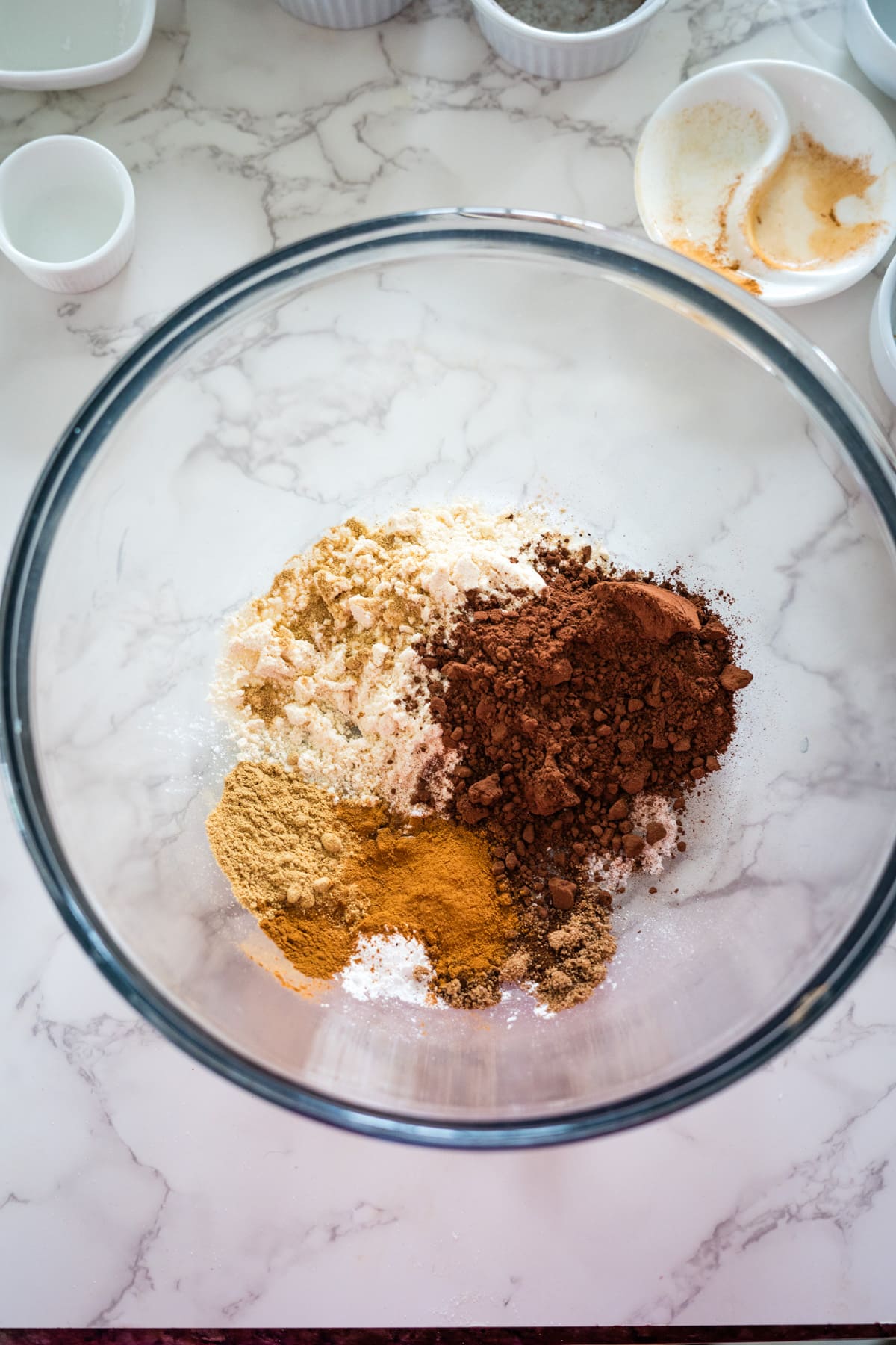 A bowl of spiced brownie ingredients on a marble counter.