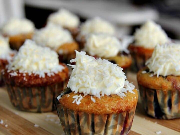 A tray of low carb mini muffins topped with whipped cream and coconut.