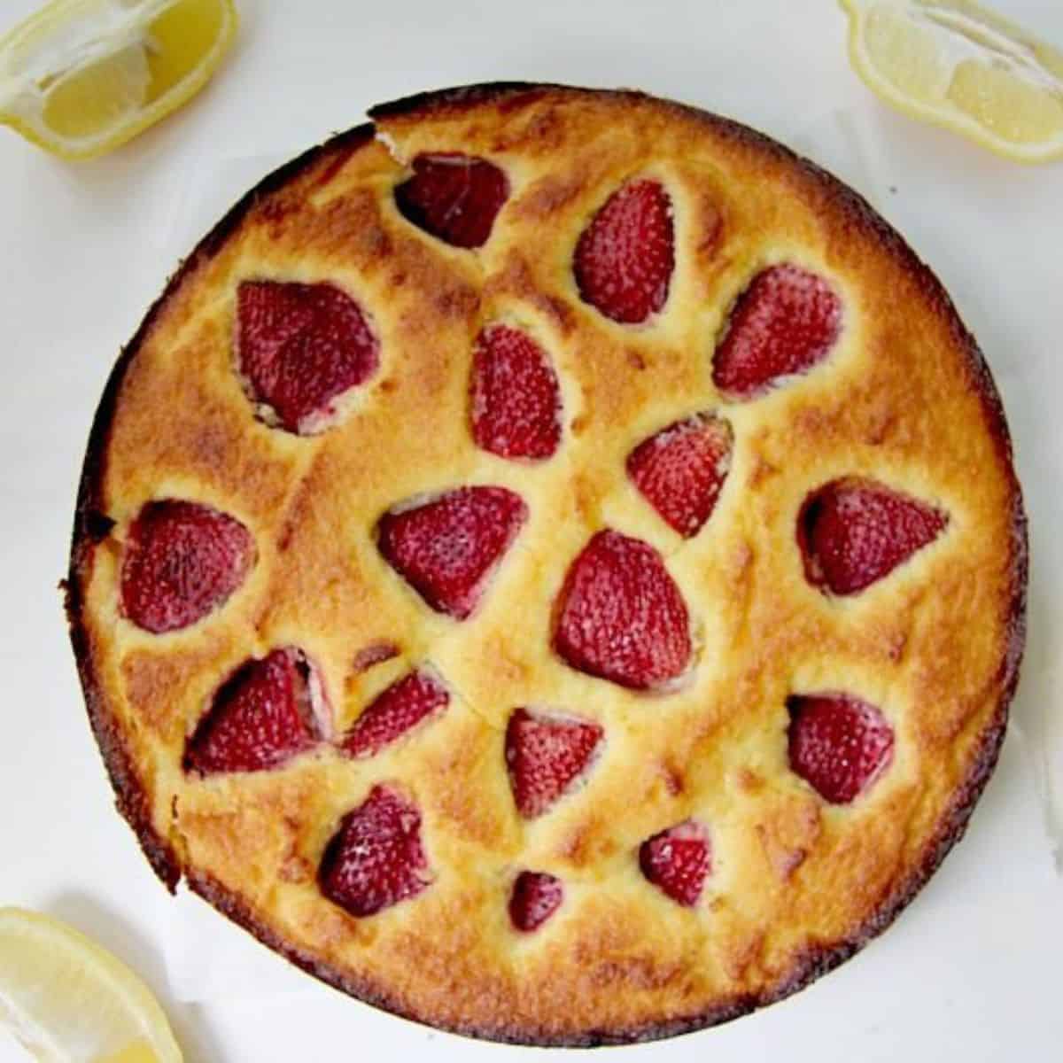 A cake with **strawberries** and **lemons** on top.