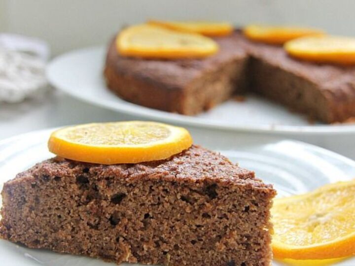 A delicious slice of chocolate cake topped with juicy orange slices.