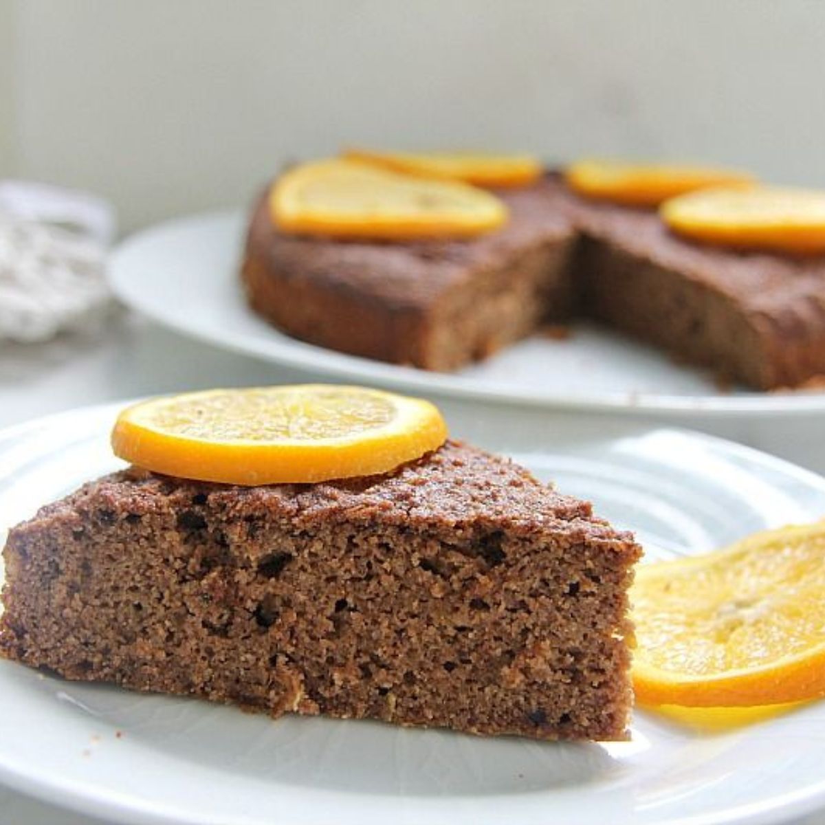 A delicious slice of chocolate cake topped with juicy orange slices.