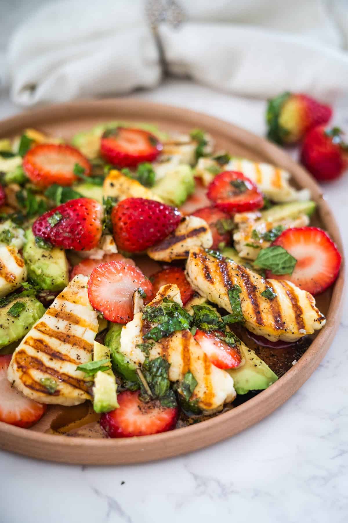 Grilled chicken salad with strawberries and avocado.