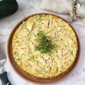 overhead view of a zucchini ricotta cheesecake on a circular plate