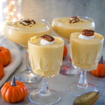 Three glasses of pumpkin mousse with pecans.