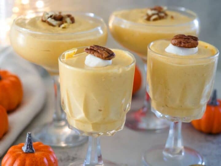 Three glasses of pumpkin mousse with pecans.
