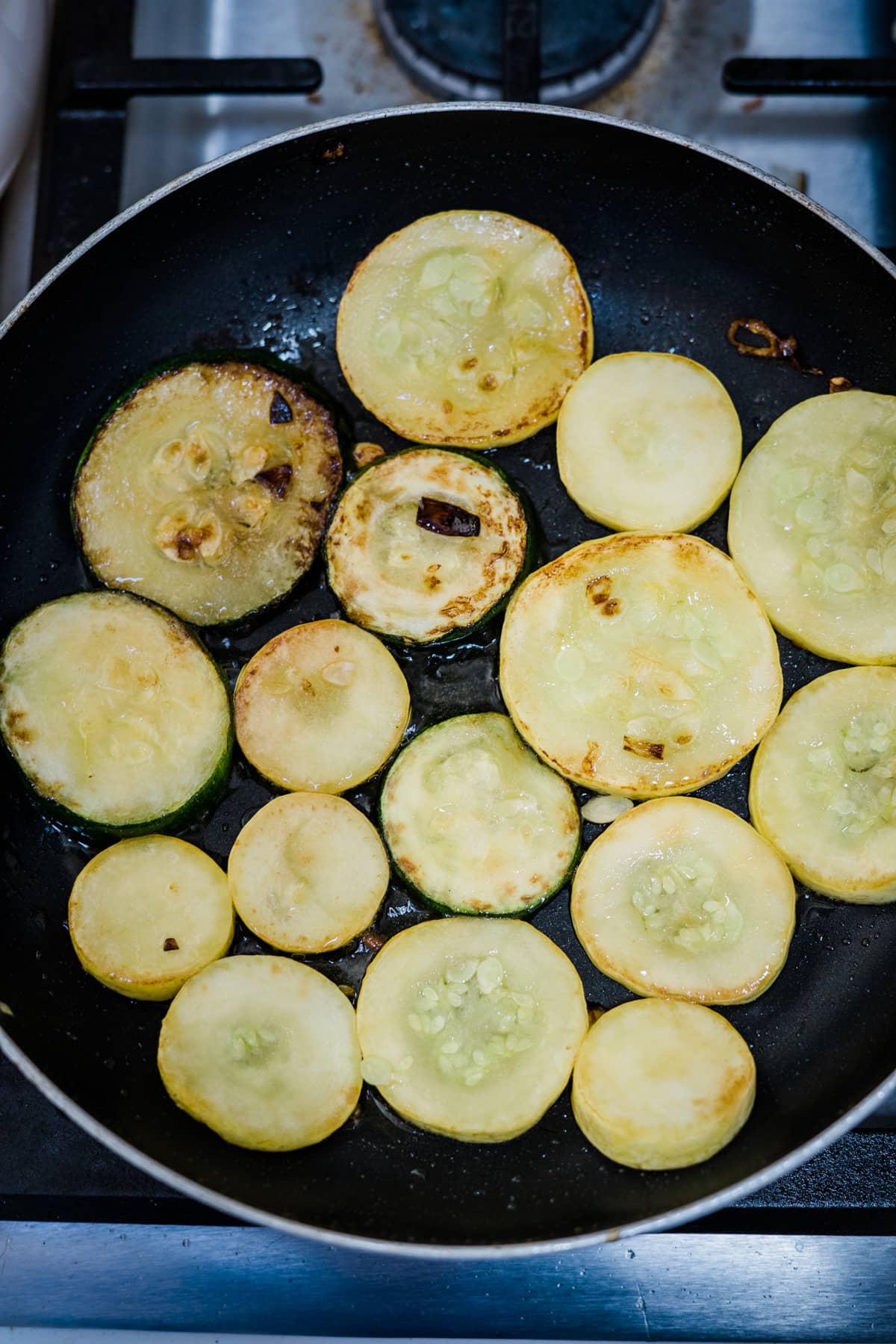 cooked zucchini slices in pan.