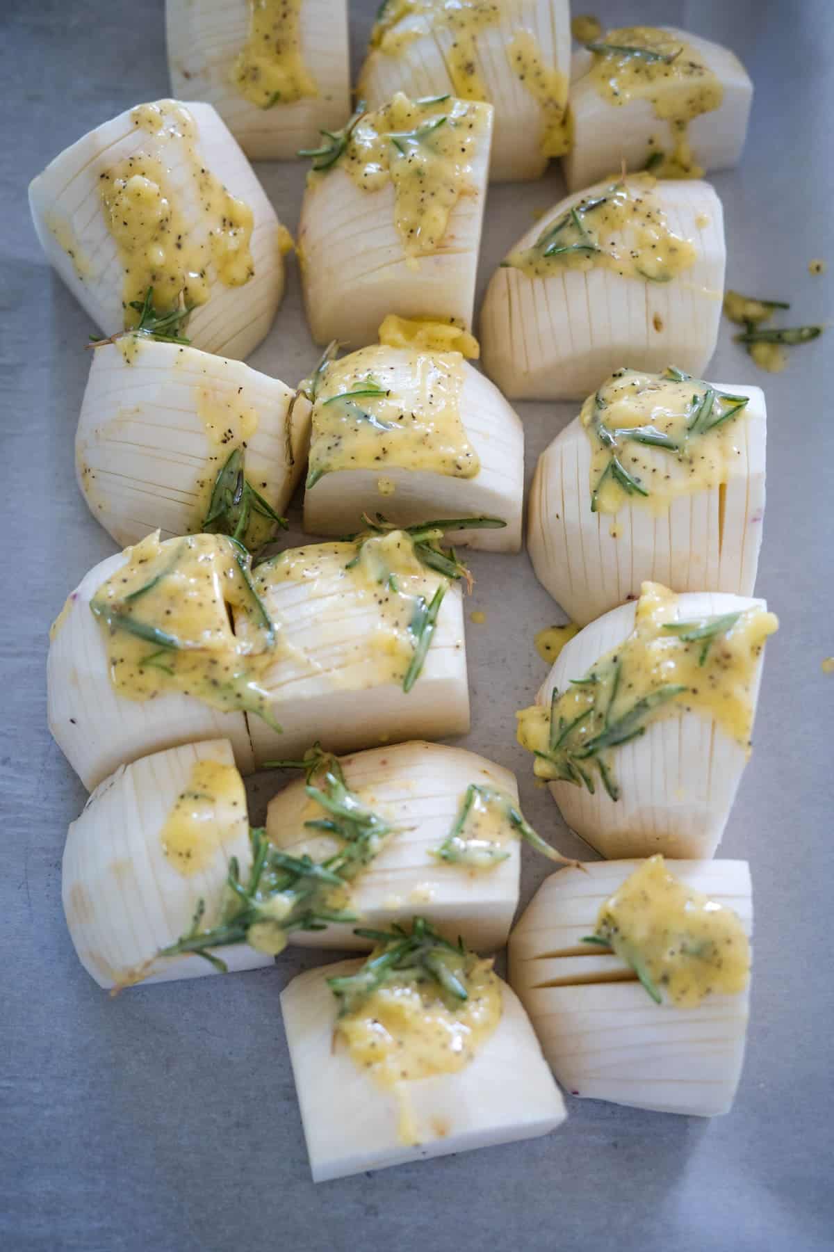Keto sliced artichokes with lemon and dill on a baking sheet.