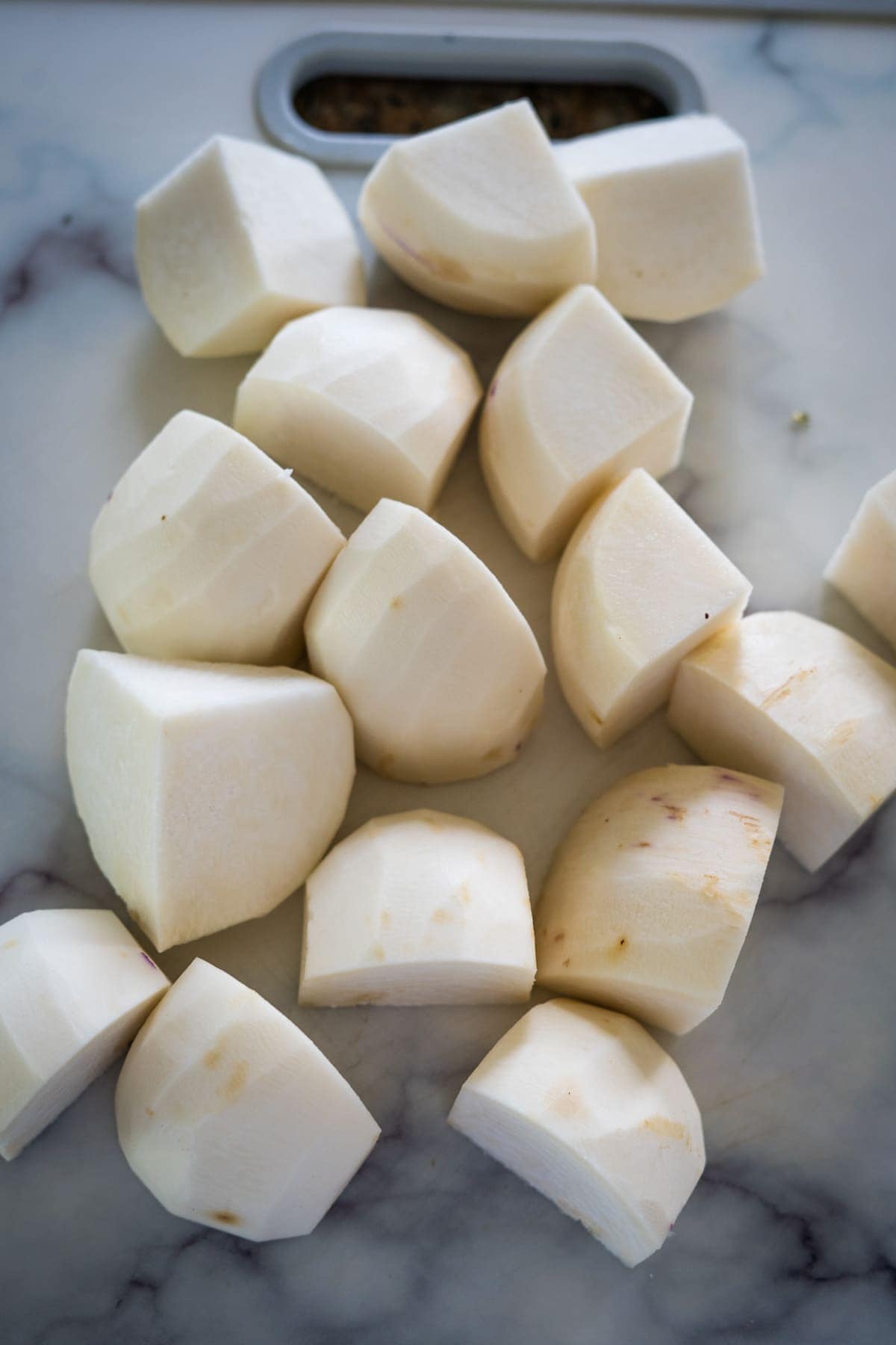Chopped garlic on a marble cutting board, perfect for keto recipes or hasselback turnips.