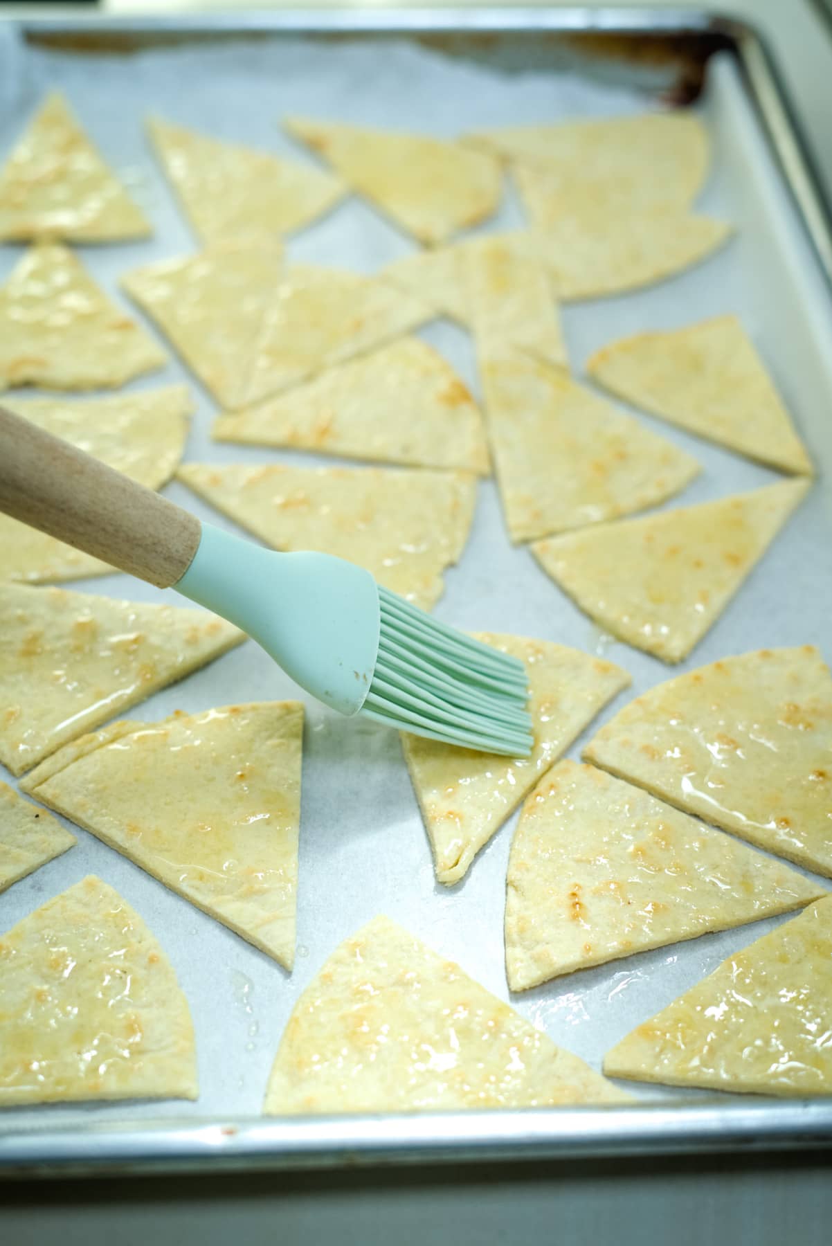 brushing tortilla chips with oil