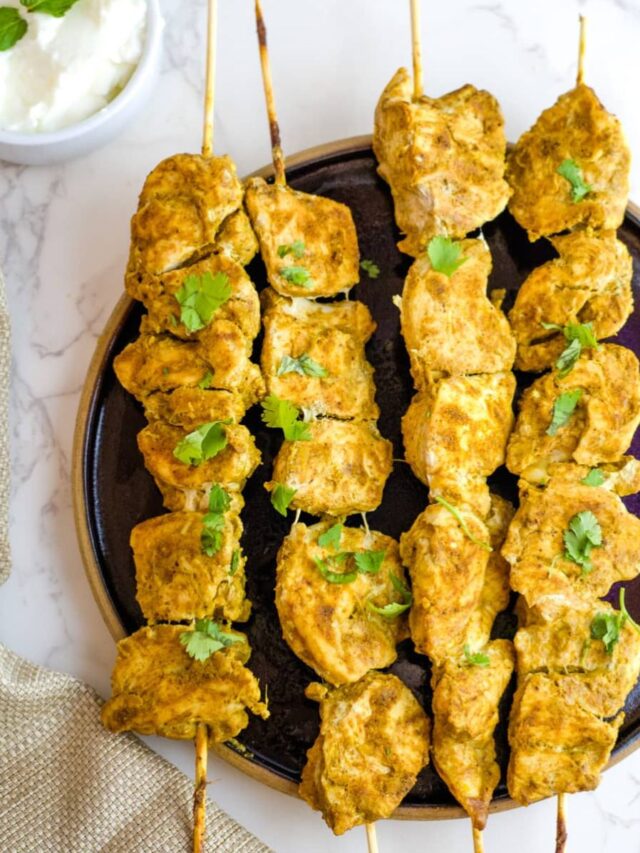 spiced chicken on skewers on a plate