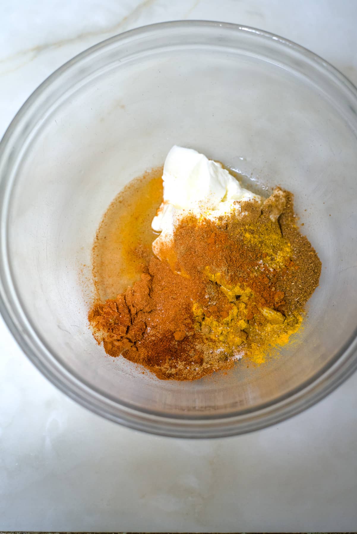 bowl of marinade ingredients with yogurt and spices