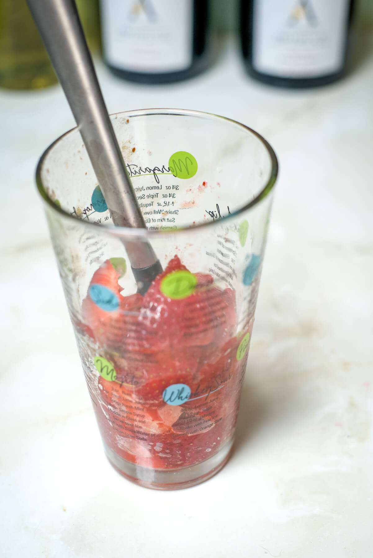 muddling strawberries in a tall glass