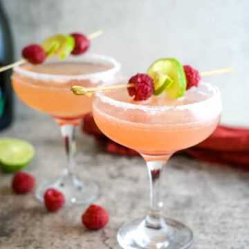 two glasses of raspberry mimosas with decorations