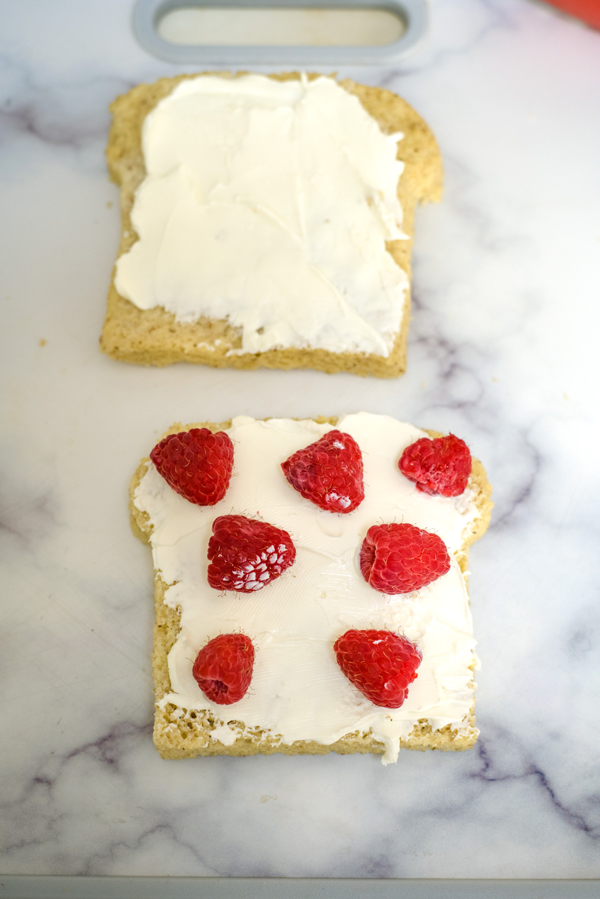 bread slices with cream cheese and raspberries