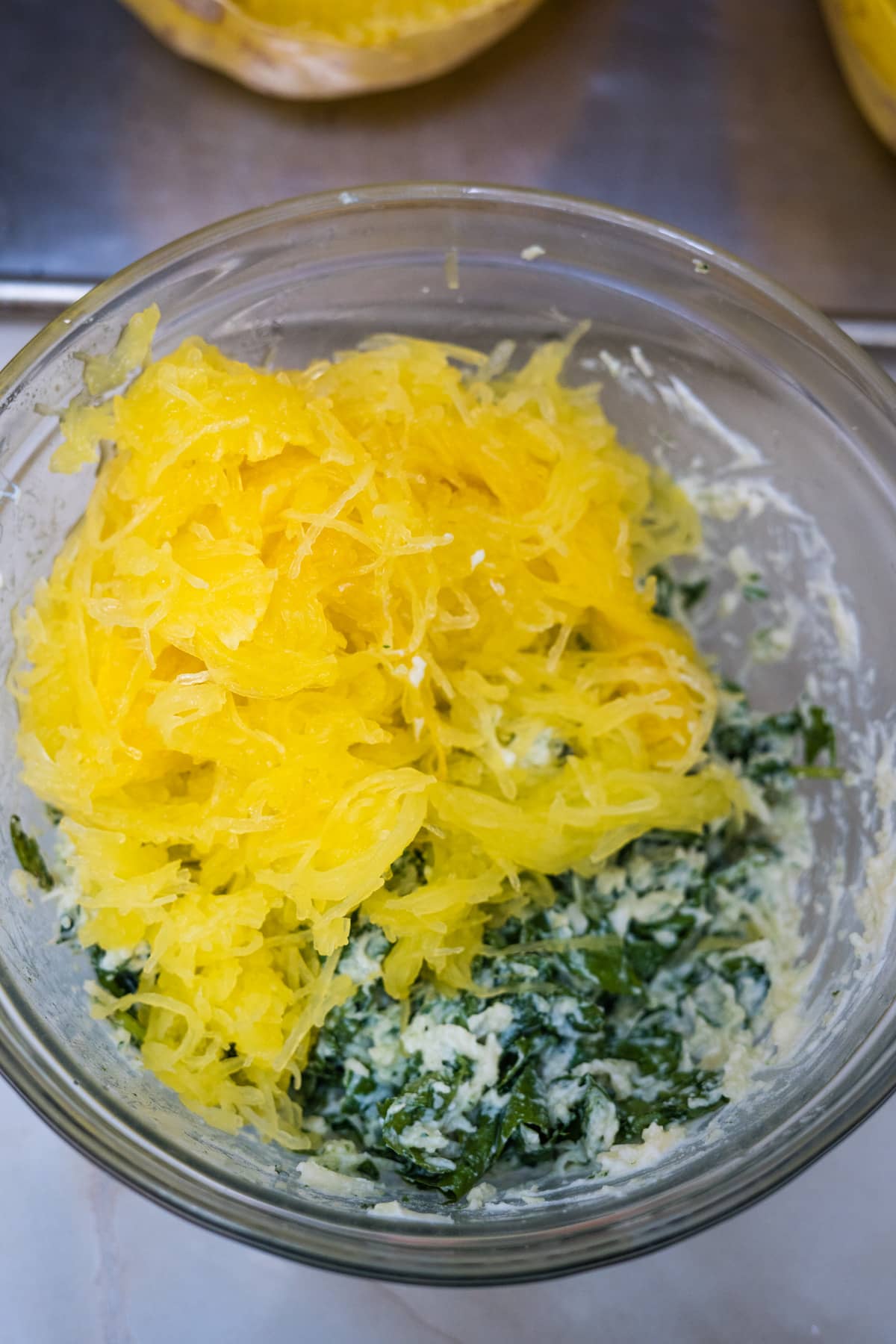 spaghetti squash in a bowl with cheese and spinach.