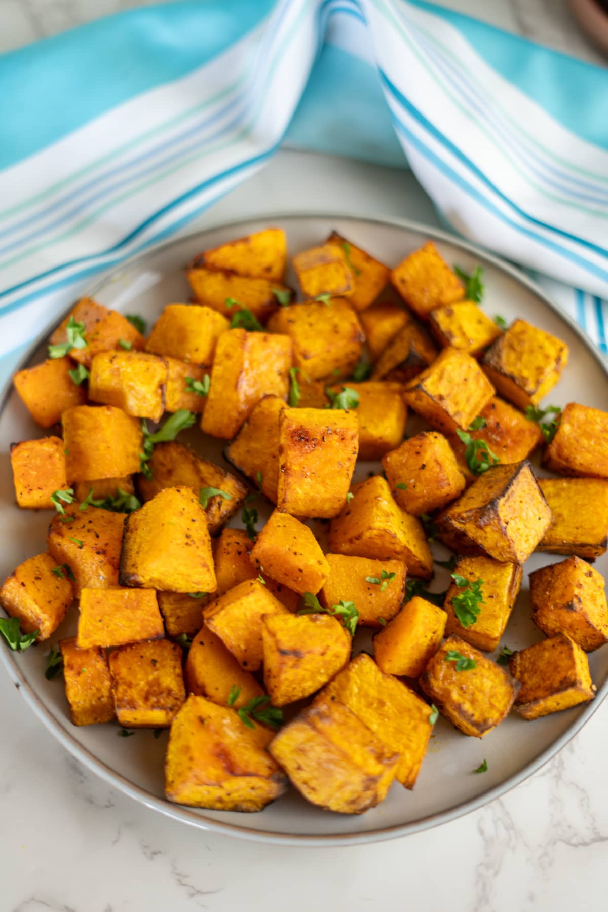 Roasted butternut squash cubes on a plate.