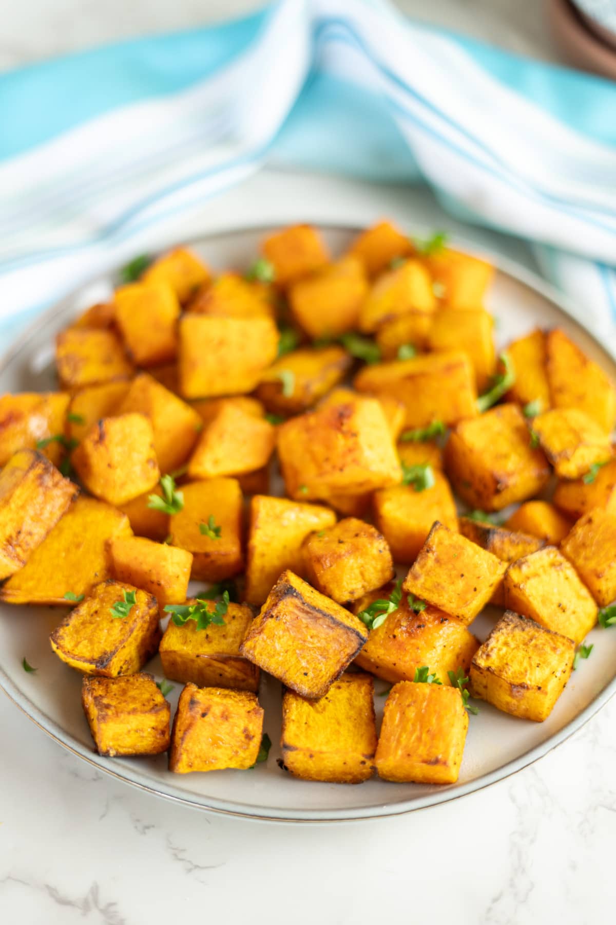 Roasted butternut squash cubes on a plate.