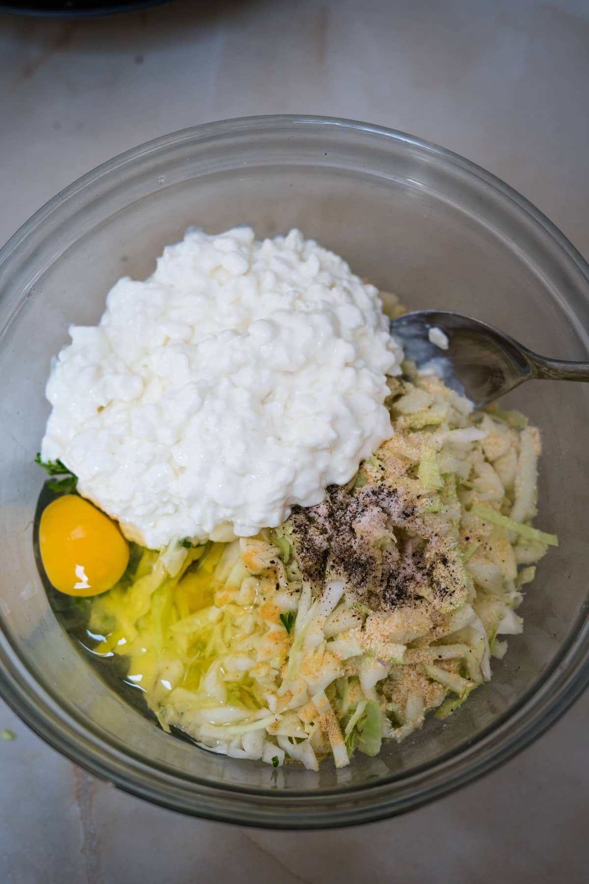 A bowl of cabbage fritters topped with rice and an egg.