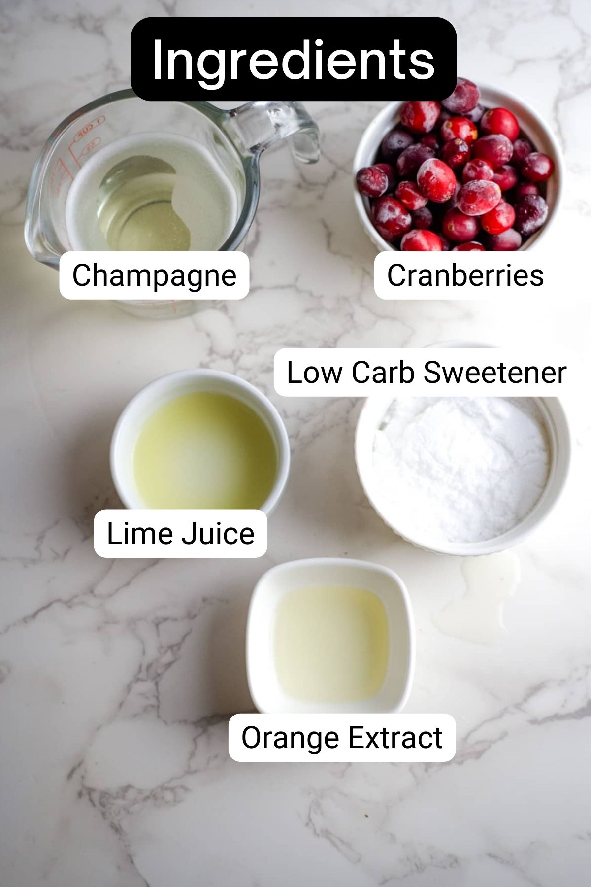 Cranberry mimosa ingredients on a marble countertop.