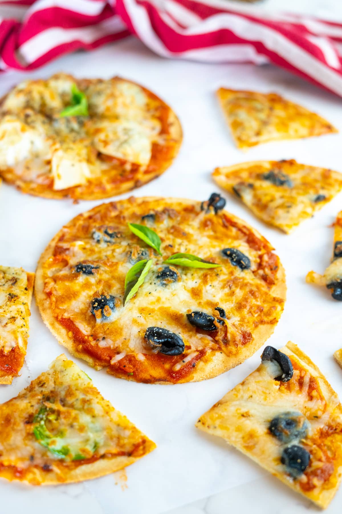 A tortilla pizza cooked in an air fryer topped with olives.