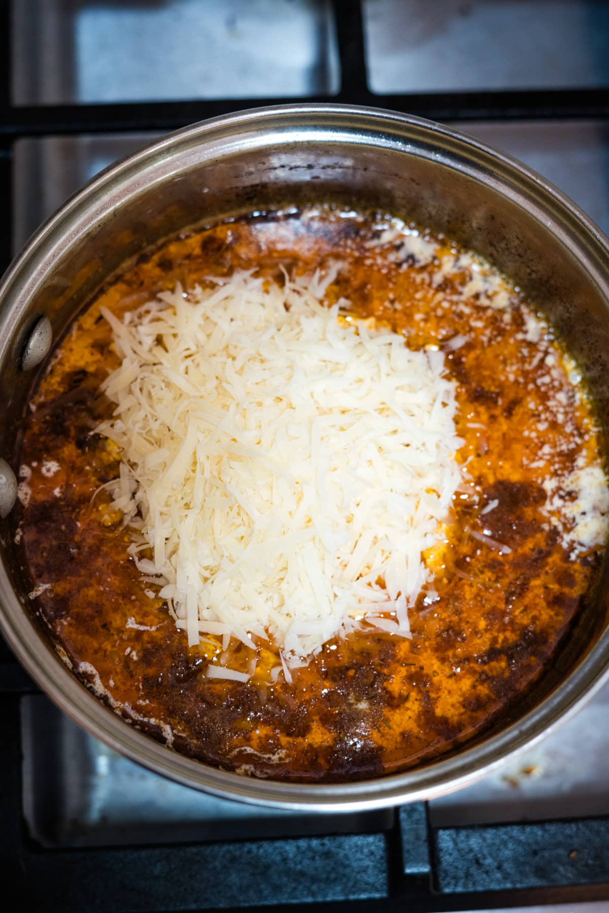 A stove top pan with Cajun alfredo sauce and cheese.