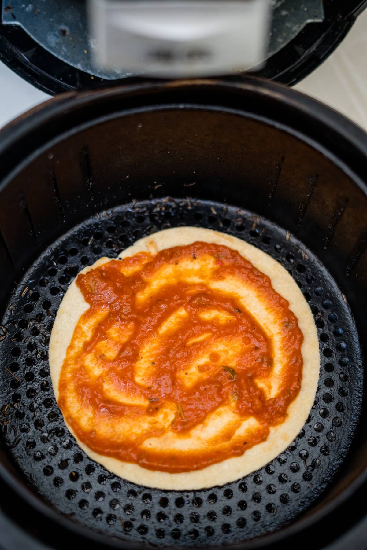 A tortilla pizza cooked in an air fryer.