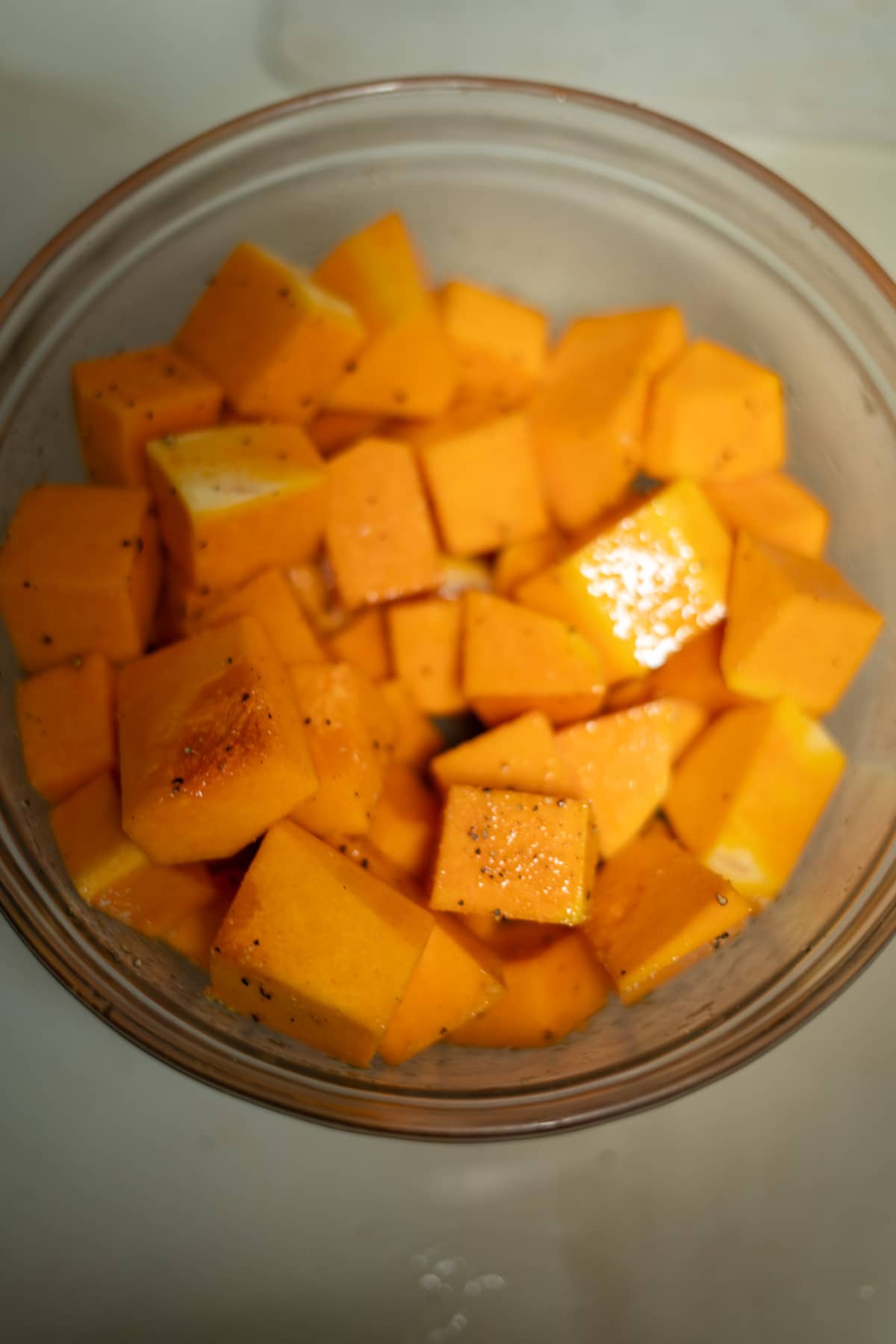 A bowl of cubed squash sitting on a counter.