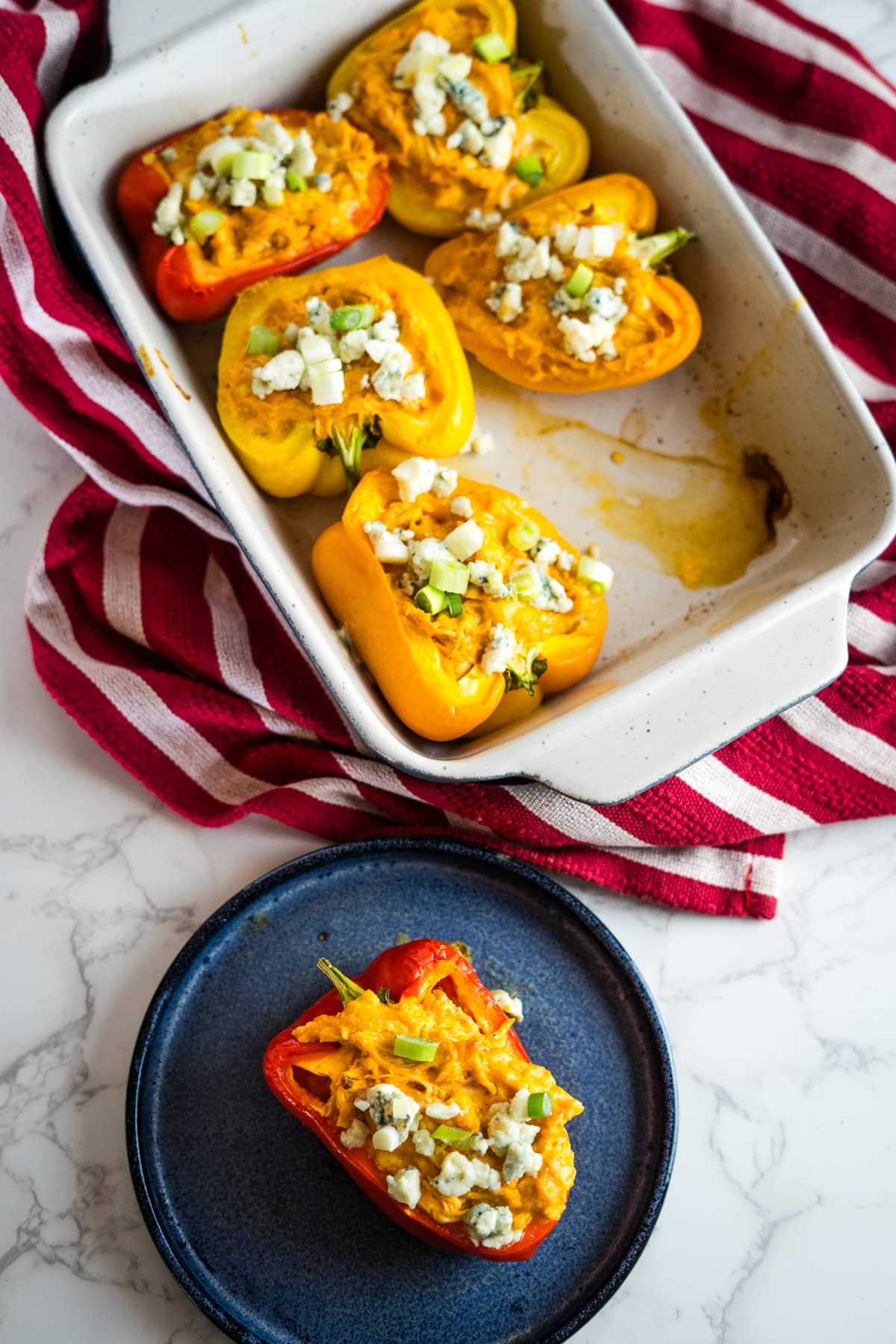 Stuffed peppers in a baking dish with buffalo chicken.