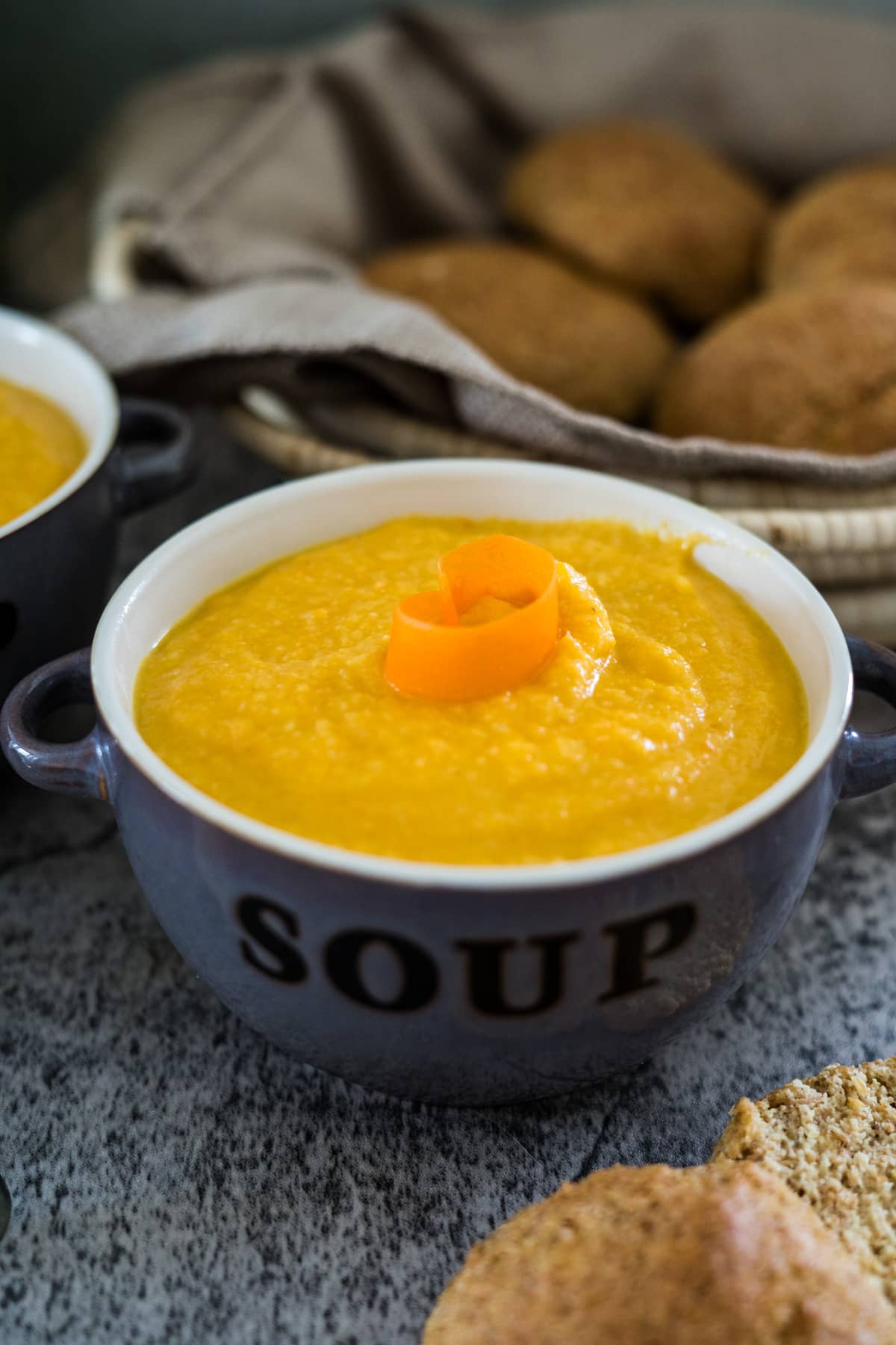 A bowl of carrot soup on a table.