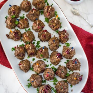 Meatballs with cranberries on a plate.
