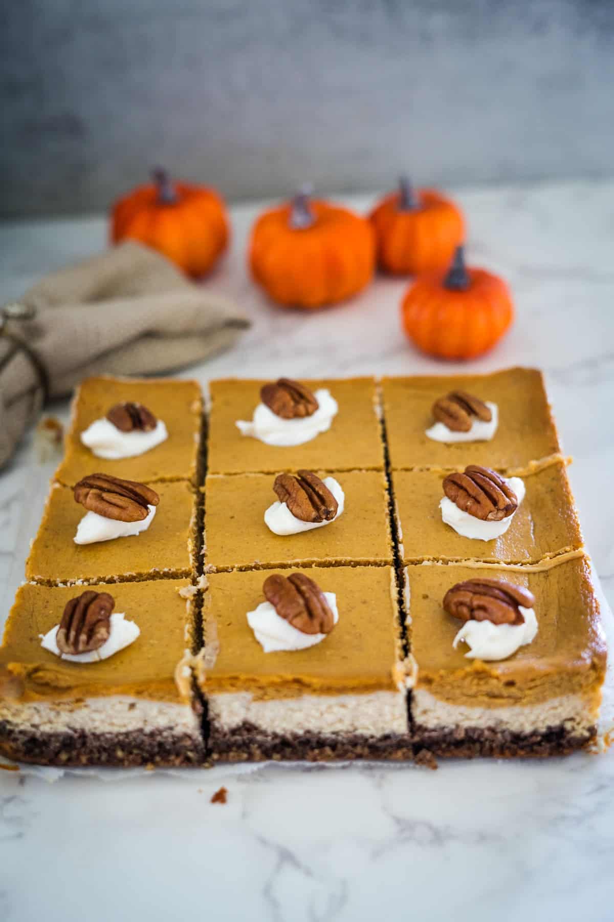Pumpkin cheesecake bars with pecans and cream cheese.