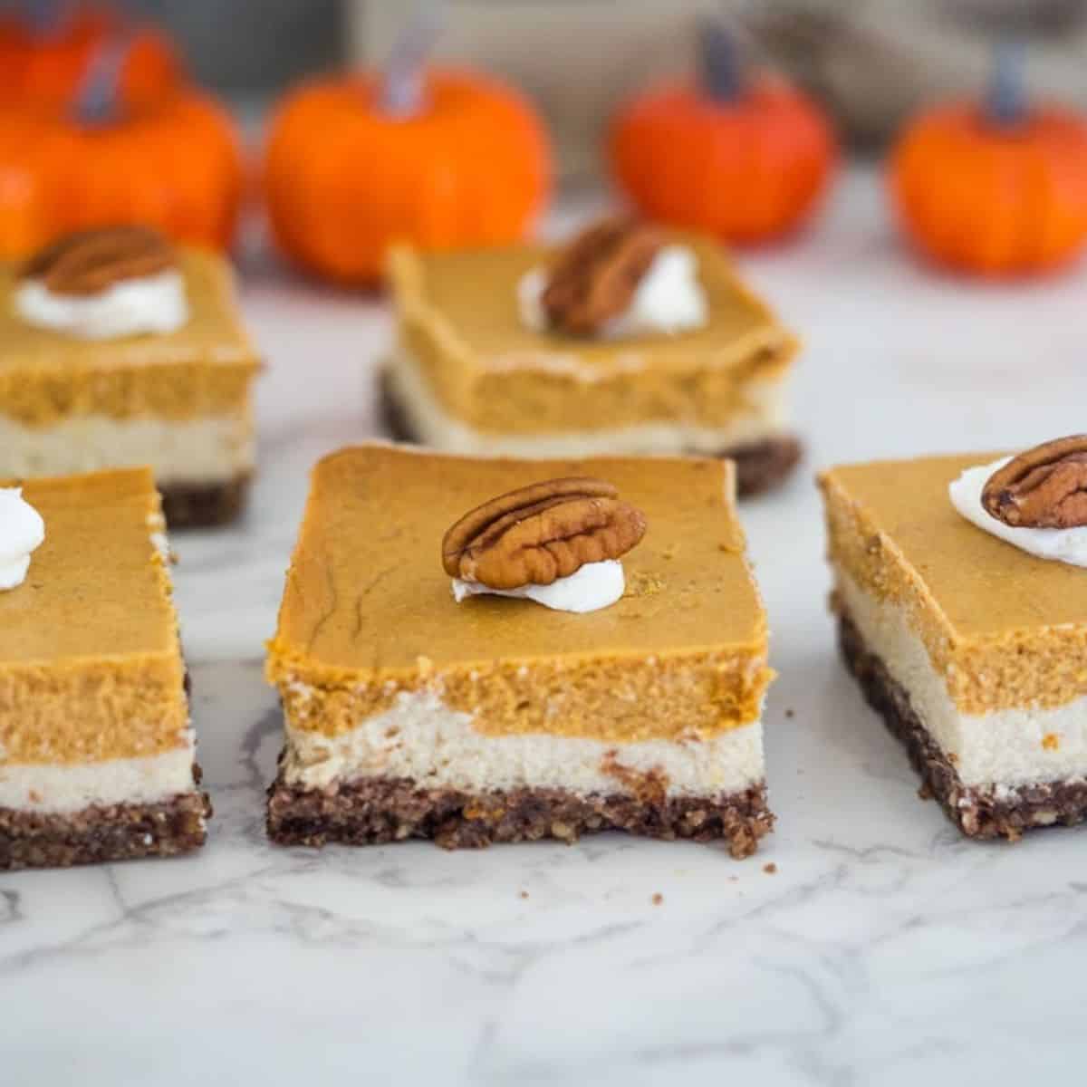 Pumpkin cheesecake bars with pecans on top.