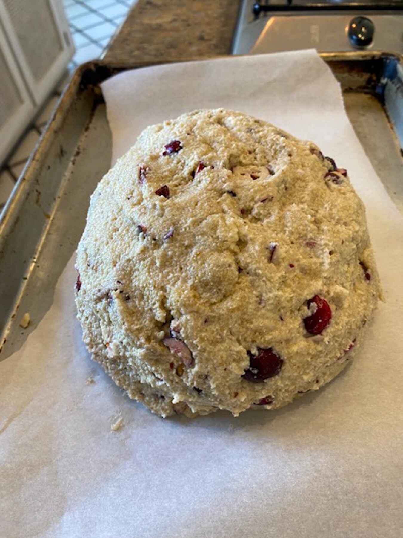 A loaf of cranberry bread sitting on a baking sheet.