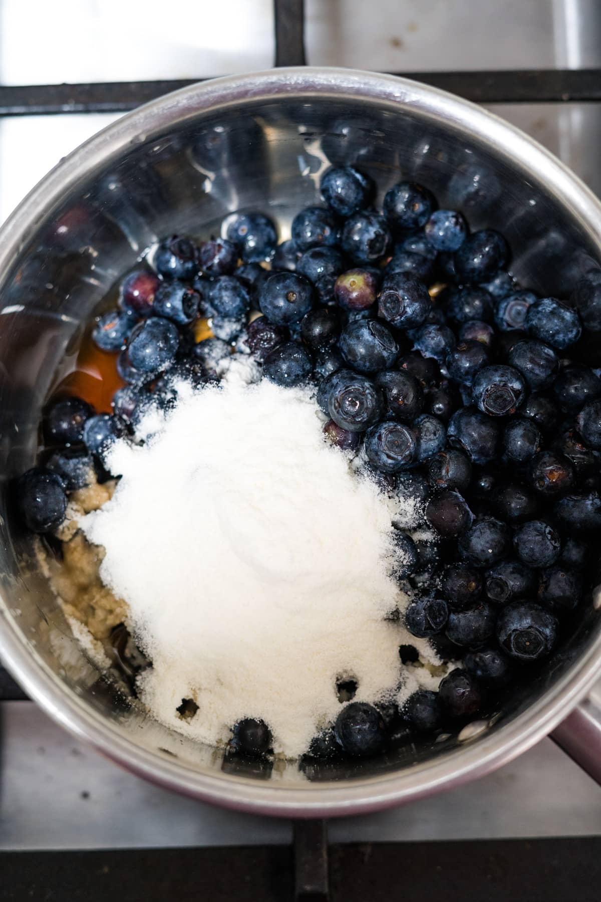 The ingredients for keto blueberry pancakes are in a pan on the stove.