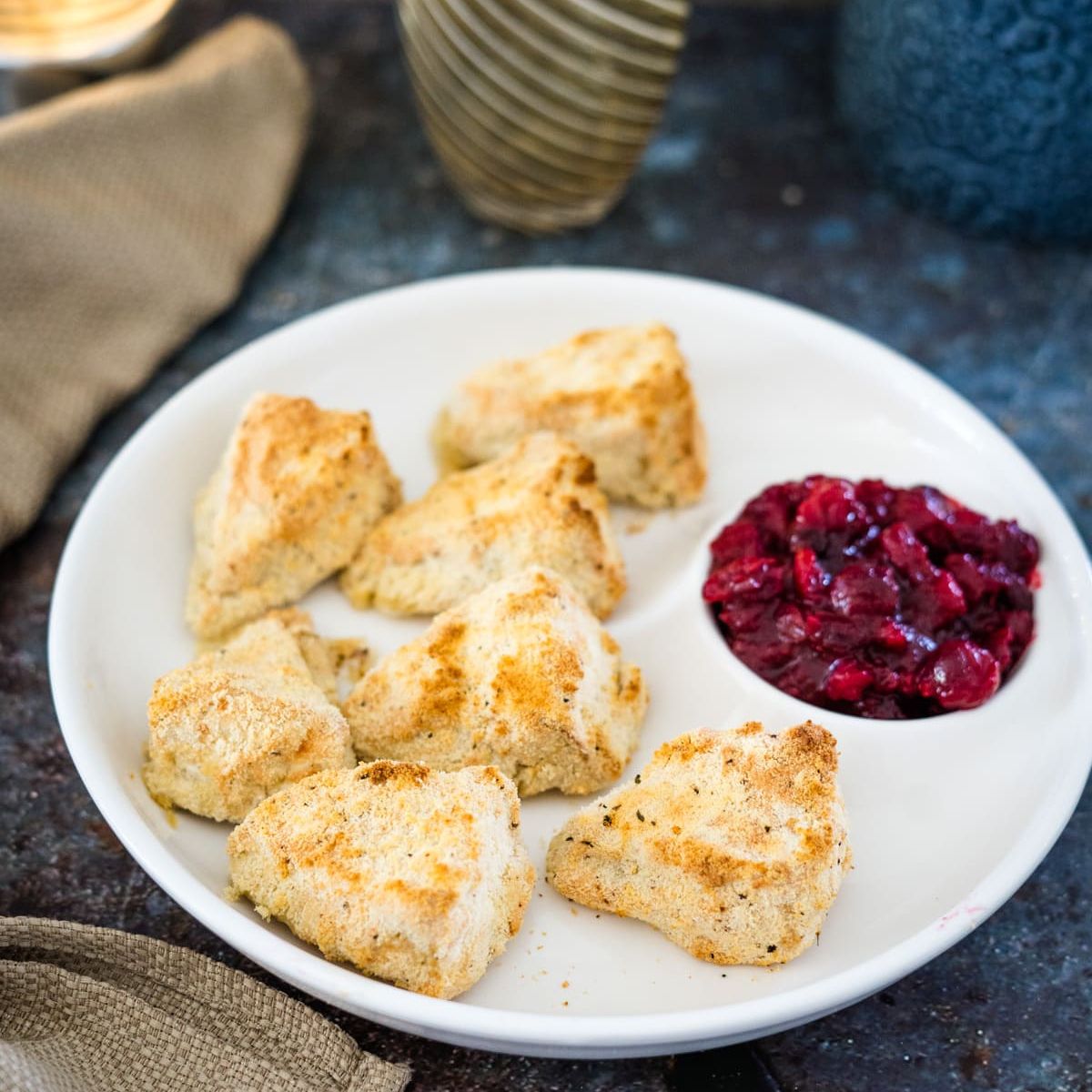Cranberry scones on a plate with cranberry sauce.